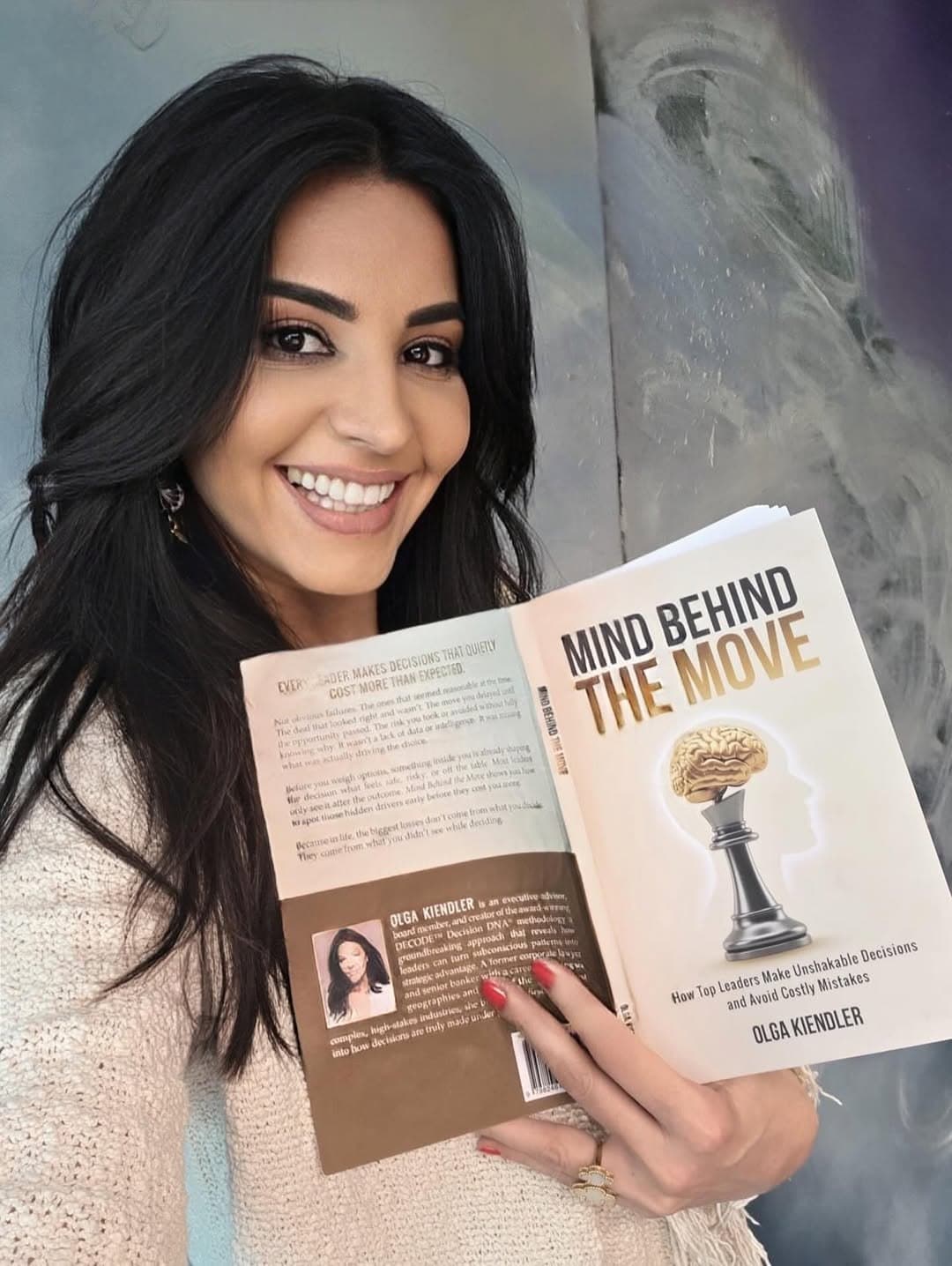 Olga Kiendler holding a copy of Mind Behind the Move
